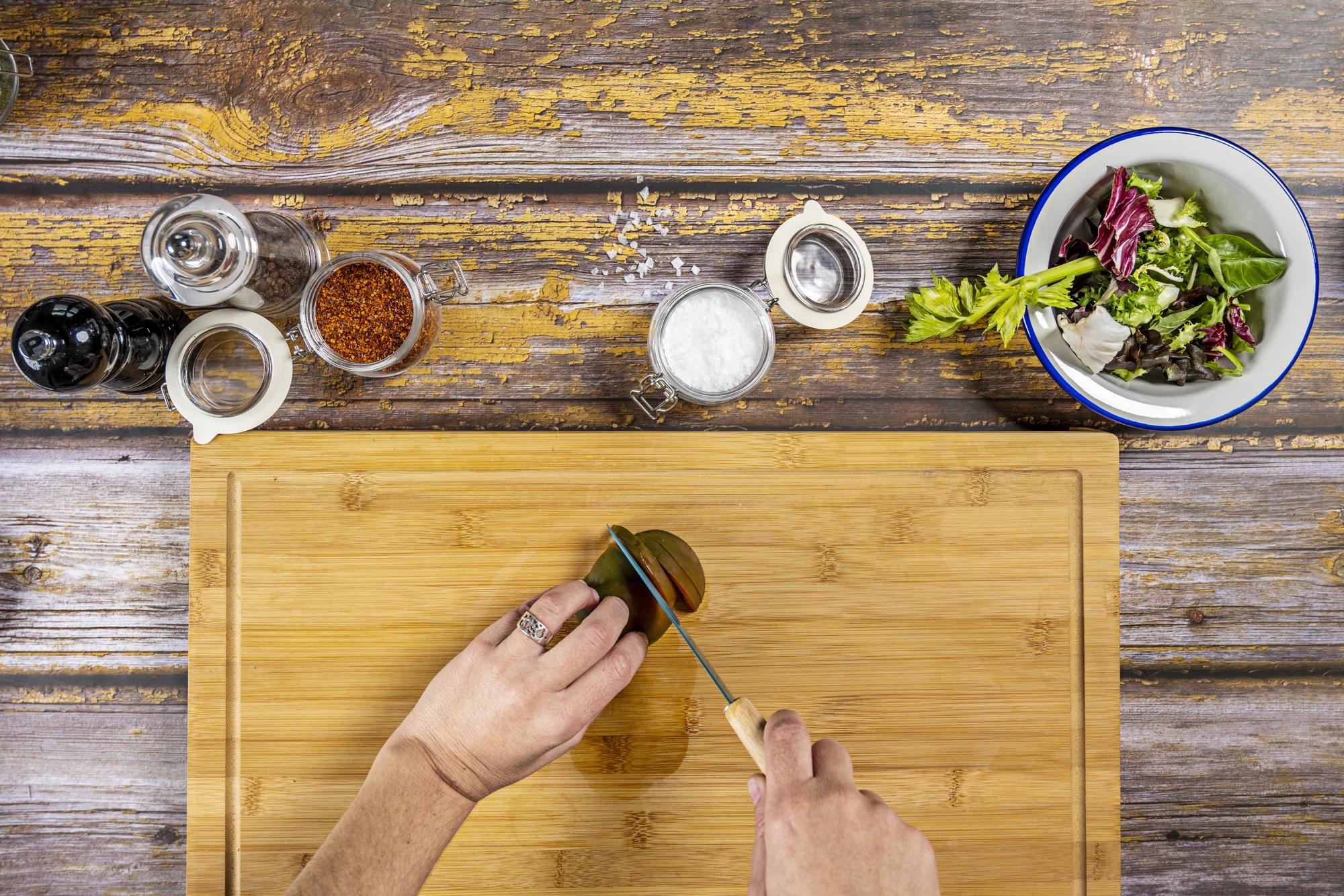 chef arranging plated tasting menu on wooden board
